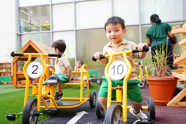 Children riding trikes on the outdoor track