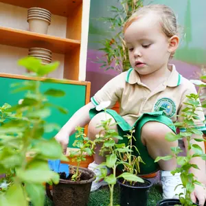 A child potting herbs at the gardening bench