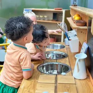 A child cooking with pots at the outdoor mud kitchen