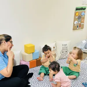 A teacher and toddlers sitting together at circle time