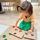 A child placing counters on a wooden number board