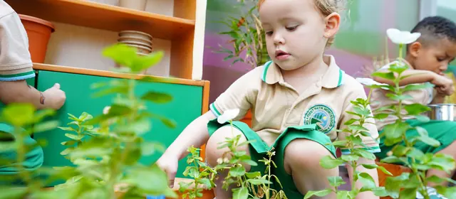 Children planting herbs at the nursery gardening bench